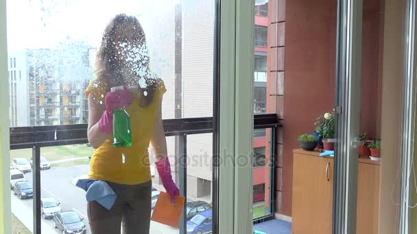 Счастливая женщина чистит окно и улыбается . — стоковое видео