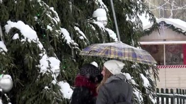 Genç gülümseyen kız şemsiye ile Noel ağacı yakınındaki iyi eğlenceler. Blizzard
