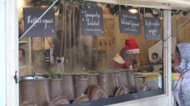 Yorgun satıcı kadın sıcak satış Noel giysileri ile iç Noel kasabası adil