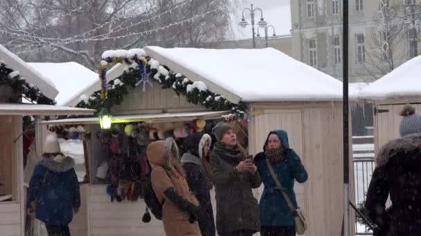 Fiatal nő karácsonyi város közelében holiday tisztességes kioszk selfy vesz. Blizzard hó — Stock videók