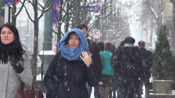 Az emberek séta a havas téli nap meleg ruhát. Blizzard hó. — Stock videók