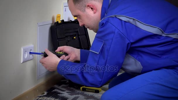 Elektricien man een muur stopcontact installeren — Stockvideo