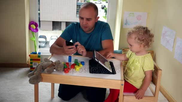 Pai com telefone inteligente e filha menina com tablet computador — Vídeo de Stock