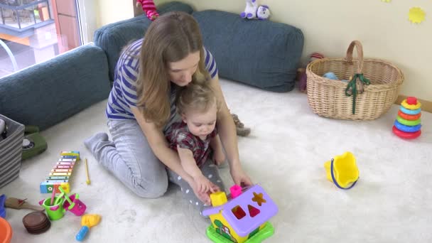 Unga älskande mamma lär dotter flicka att skilja objekt former. — Stockvideo