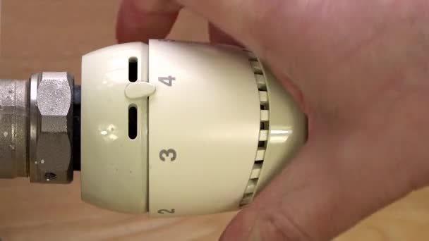 Мужская рука выключает термостат радиатора — стоковое видео