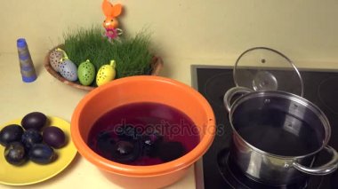 Eli kaşık ile kaynar boya ile boyanmış yumurtadan çıkar.