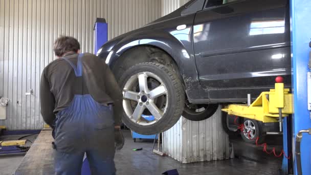 Auto mecánico quitar la rueda del coche — Vídeo de stock