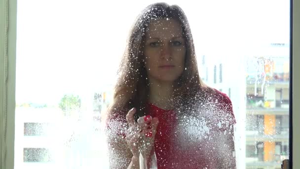 Cheerful girl woman spraying chemical and washing window. — Stock Video