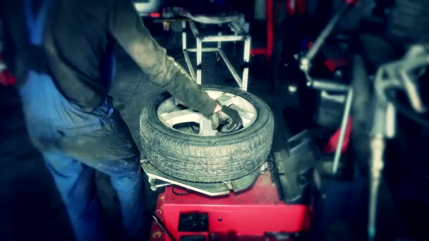 Mechanik mění pneumatiky v autoservis. Pneumatiky rotační stroj — Stock video