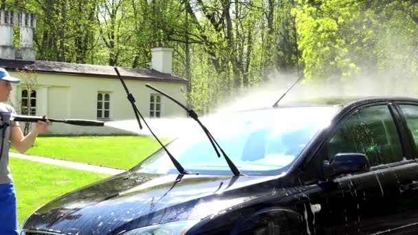 Hombre trabajador con herramienta de chorro de agua de alta presión lavando su automóvil . — Vídeos de Stock