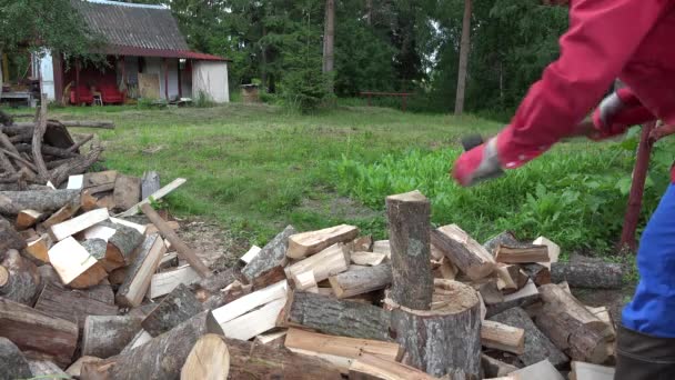 Сильный деревенский человек готовит натуральное древесное топливо для зимы в провинции. 4K — стоковое видео