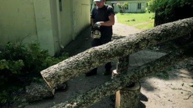 Erkek bahçıvan başlangıç chainsaw ve testere ağaç gövdesi evin bahçesinde giriş üzerinde düşmüş