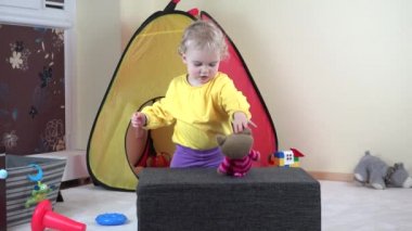 Şirin Bebek kız oyun ile oyuncak kedi ve yumuşak Puflar evde tırmanmaya.