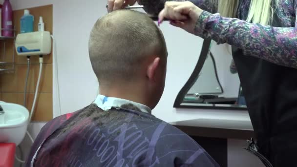Мужчина стрижется перед зеркалом парикмахерской. 4K — стоковое видео