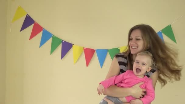 1 year old baby girl dancing with mother on her hands on yellow background — Stock Video