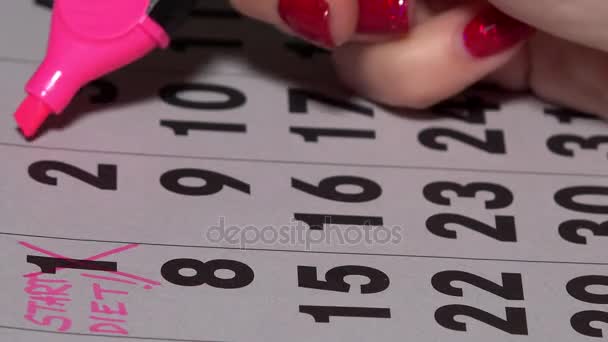 Dita di donna con marcatore rosa che attraversa giorni su calendario. Inizio del concetto di dieta — Video Stock