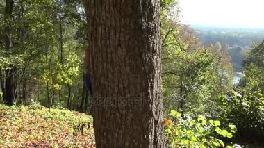 Şirin Bebek oyun saklamak ve tohum ağaç gövdesi sonbahar Park üzerinden annesiyle. 4k