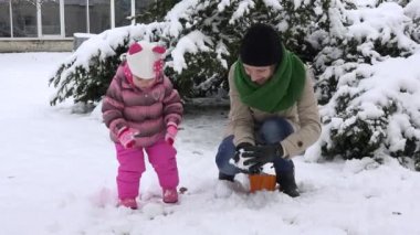 kadın kızı ile kartopu atmak. Mutlu aile kızlar. düşen kar