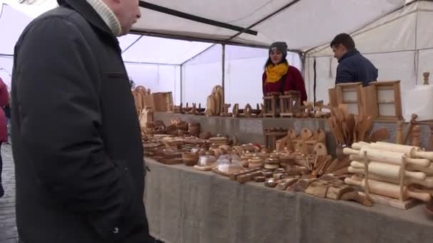 Hübsche Frau und ihr Mann verkaufen auf jährlichem Frühlingsmarkt hölzerne Küchenutensilien — Stockvideo