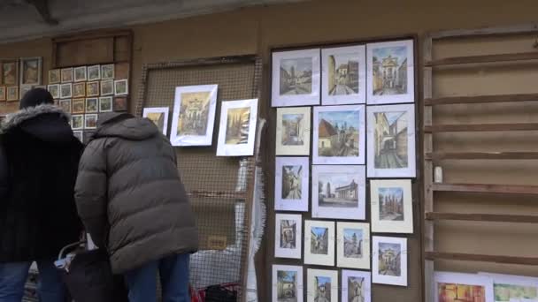 Schilderijen te koop hangen aan een muur van de oude stad. Steadicam — Stockvideo