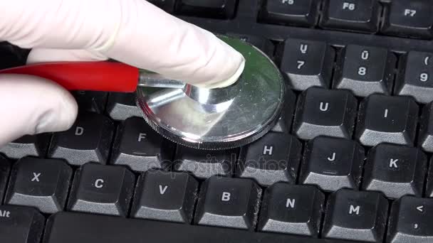 Mano con guantes y estetoscopio en el teclado. Concepto de diagnóstico informático — Vídeo de stock