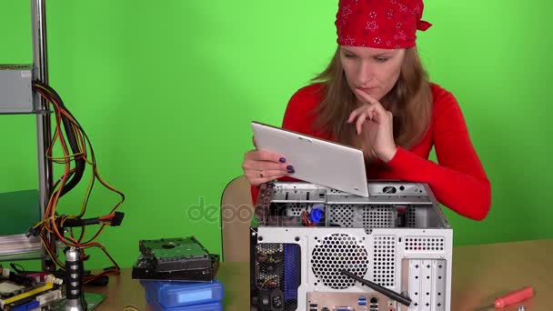 Женщина-техник с планшетным компьютером осматривает компьютер в ремонтной службе — стоковое видео