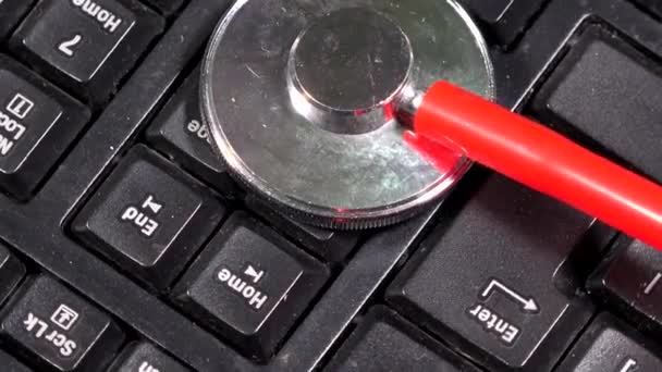 Estetoscópio vermelho no teclado. Conceito de diagnóstico por computador — Vídeo de Stock