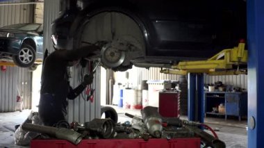 otomatik mekanik adam onun garajda araba fren sistemi onarmak için çeşitli araçları kullanın.