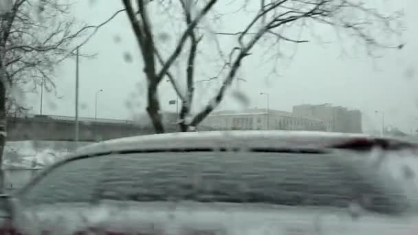 Car drive throw snowy frozen street in winter. Cars covered with snow fall — Stock Video