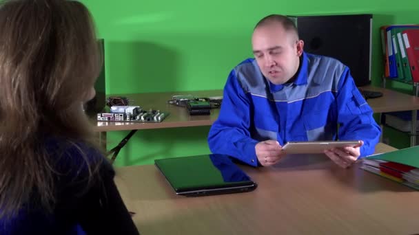 Недбалий технік чоловік розмовляє з жіночим клієнтом по ремонту комп'ютерів — стокове відео