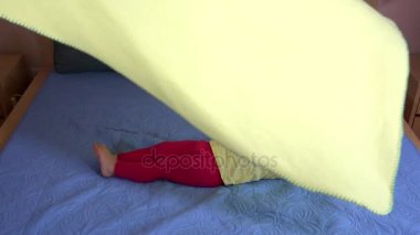 Yürümeye başlayan çocuk kız yatakta döşeme sarı ekose halı oynamaktan zevk