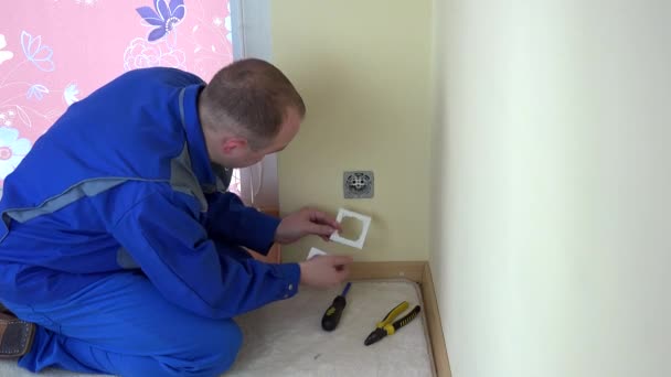 Trabalhador reparar uma tomada de parede elétrica no trabalho — Vídeo de Stock