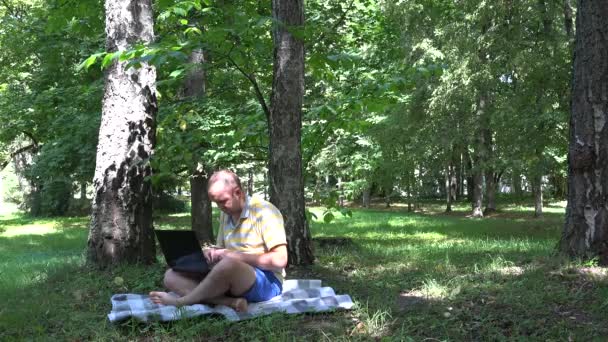 Freelancer autônomo homem usando laptop na natureza. 4K — Vídeo de Stock