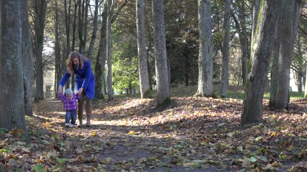 Счастливая мама с маленькой девочкой веселятся в осеннем парке. 4K — стоковое видео