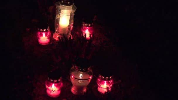 Ljusen brinner på gravar på kyrkogården på natten. All Hallows Eve. 4k — Stockvideo