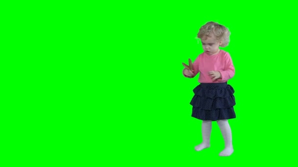 Мила дівчинка поклала золоті партійні окуляри на голову ізольовані на зеленому — стокове відео