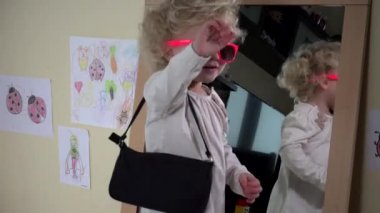 Pembe güneş gözlüğü ve ayna önünde el çantası poz ile şirin bebek kız