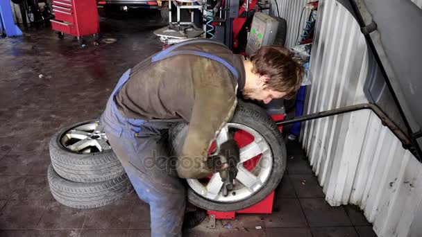 Mechanic balancing a car wheel on an automated machine checking — Stock Video