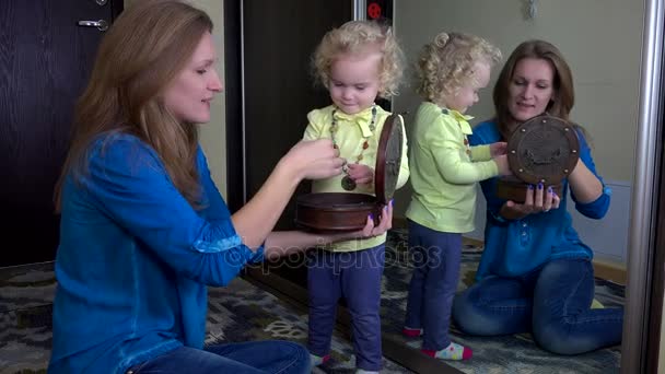 Счастливая мать дарит дочери браслеты из ретро-коробки перед зеркалом — стоковое видео