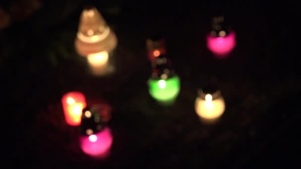 Focus change of colourful candle on grave ground in dark. 4K — Stock Video