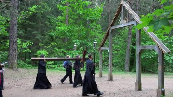 Sacerdote e pellegrino cristiano portare croce a Cristo dolore modo stazione e pregare — Video Stock