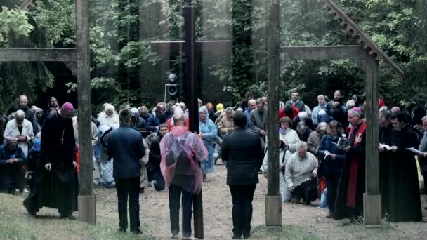 Religious people and priests kneel down on knees and pray against cross — Stock Video