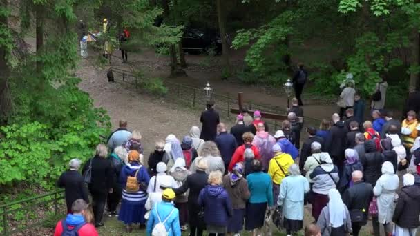 Catholic priests and christian people procession carrying wooden cross down hill — Stock Video