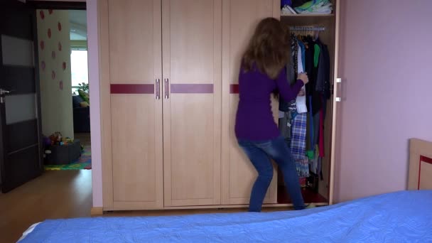 Madre juguetona con su hija niña esconderse en el armario y cerrar la puerta — Vídeo de stock