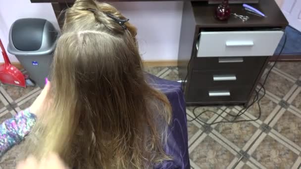 Vrouwelijke professional maken kapsel langharige meisje in salon. 4k — Stockvideo