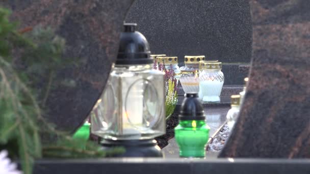 Luz de la vela a través de la cubierta de vidrio en la tumba en el cementerio de la ciudad. 4K — Vídeos de Stock