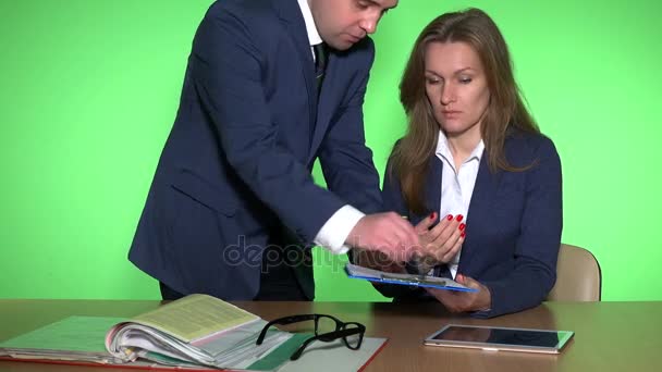 Jefe masculino comprobando documentos y estresado empleado chica en fondo verde — Vídeo de stock