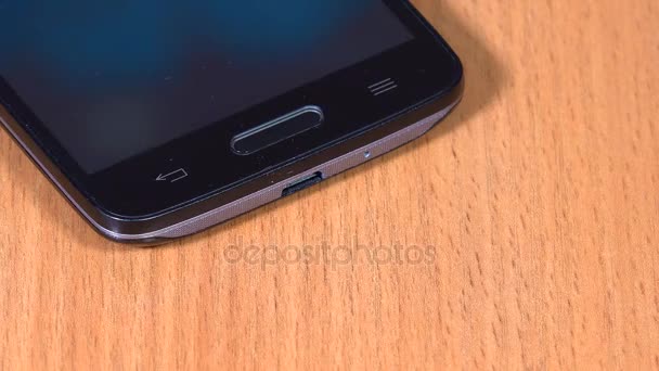 femme brancher le câble noir à l'appareil intelligent. gros plan 