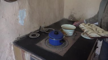 Yaşlı kadın eller köfte lor ile tencerede soba eski ateşe koy. 4k