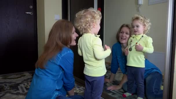 Schattig meisje maatregel ketting met haar moeder voor spiegel — Stockvideo